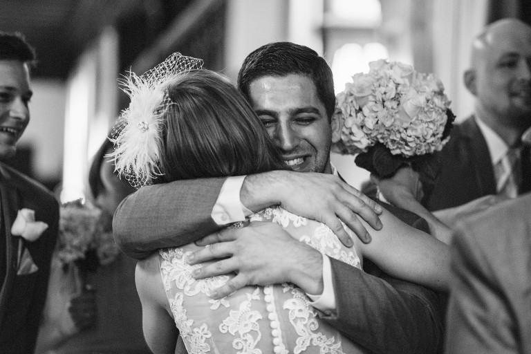 emotional groomsman hugs bride,