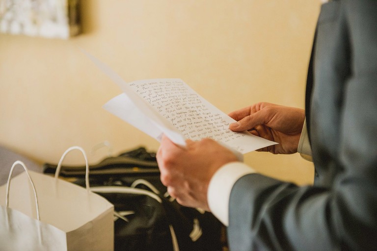 closeup of groom reading note from bride,
