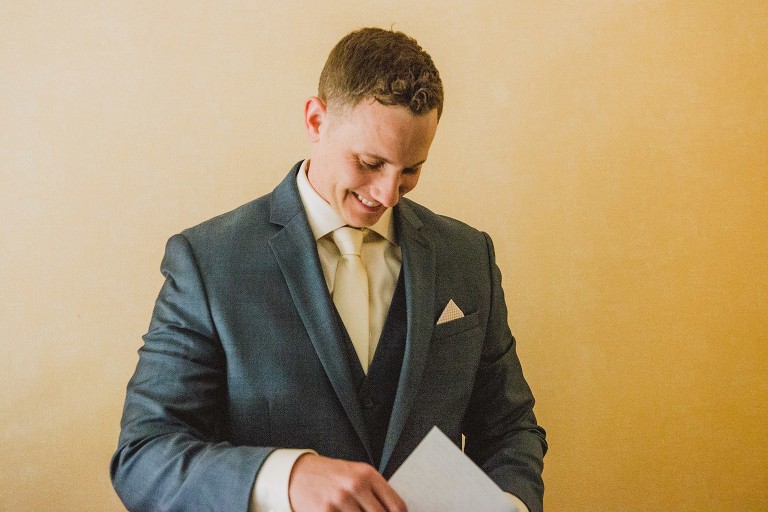 groom smiling after reading note from bride,