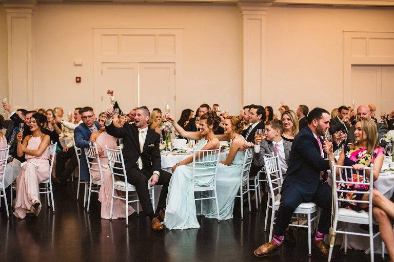 guests rasing glasses during lakeview pavilion wedding,