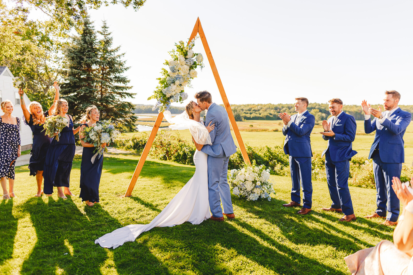 Bride and groom first kiss in front of triangle alter